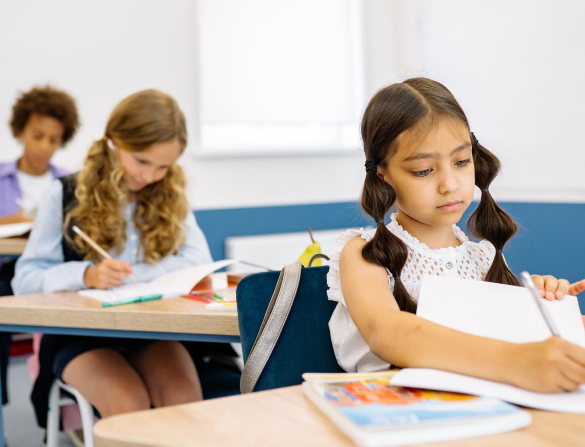 Children engaged in writing activities in a classroom